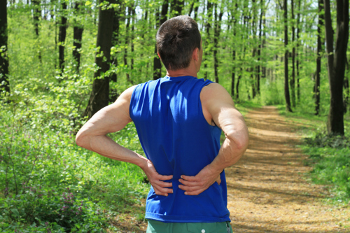 Runner holding lower spine